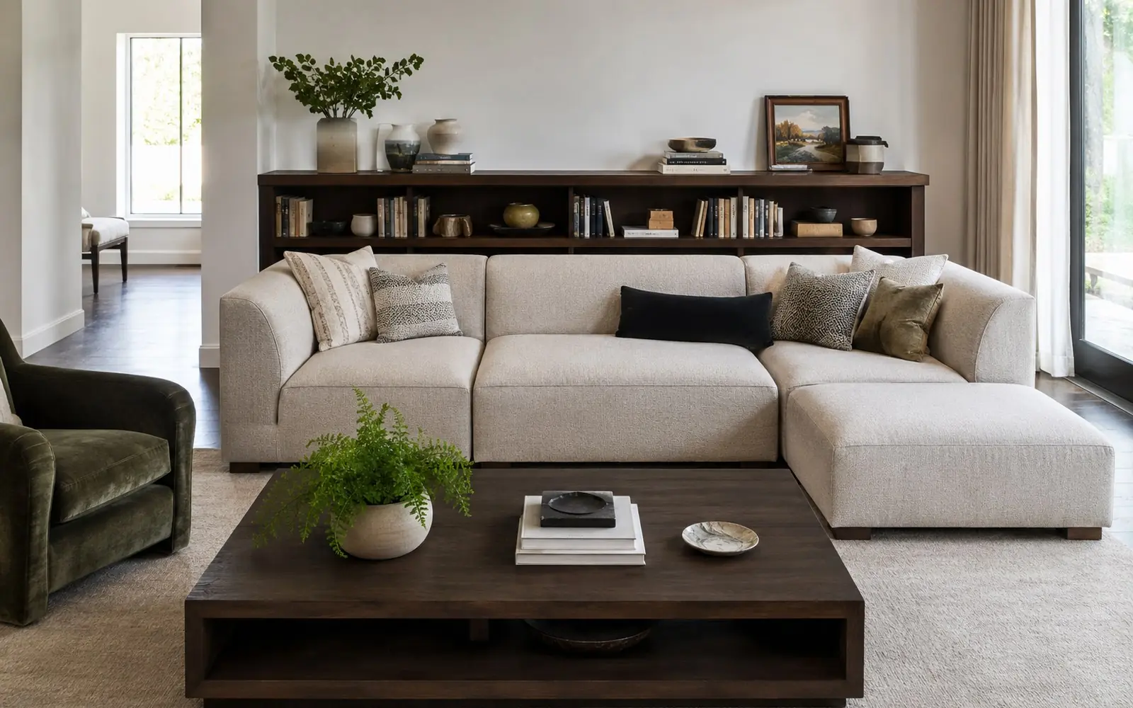 A modular fabric sectional made of four separate units pushed together, with a rectangular coffee table in front and a low bookcase against the wall behind.