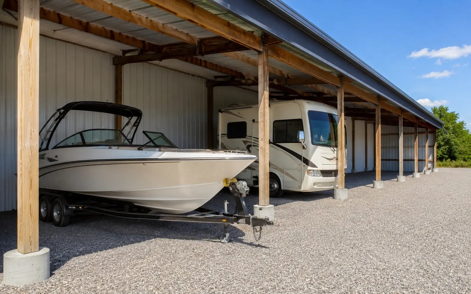 Covered storage bay with a boat on a trailer and an RV parked in clean rows